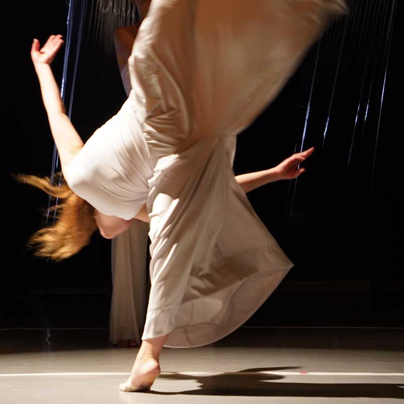 Na zdjęciu tancerka w trykocie sznuruje puenty.