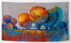 Na zdjęciu przykład pracy tkackiej jednego z uczestników kursu. Praca przedstawia impresyjny zachód słońca na tle parku, który objawia się podzieleniem drzew na barwy ciepłe (po lewej stronie) i zimne (po prawej stronie). Chłodny odcień niebieskiego przypomina również cień.