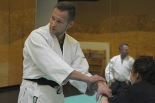 Zdjęcie przedstawia instruktora aikido prezentującego chwyt uczestnikowi warsztatów. 