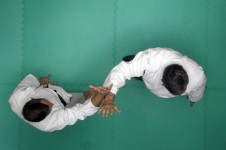 Na zdjęciu widoczne są dwie postacie zawodników aikdio w pozycjach walki. Zdjęcie zrobione z góry, znad zawodników.