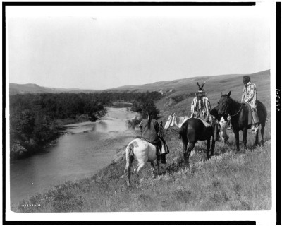 Edward S. Curtis, Indianie na wzgórzu, około 1910, ze zbiorów Biblioteki Kongresu USA, na zdjęciu widać kilku indian na koniach, są odwróćeni tyłem do fotografa, patrzą w dal, na wgrzórze i rzekę po lewej stronie zdjęcia.