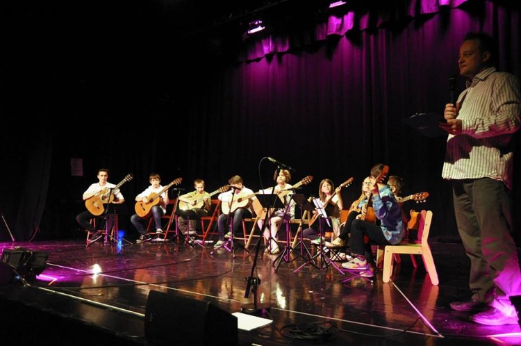 Na zdjęciu widoczna jest grupa uczniów warsztatów gitarowych na scenie SDK. 