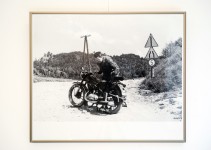 Zdjęcie Artysty przy motocyklu na piaszczystej drodze.