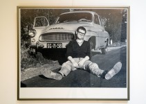 Zdjęcie ukazujące Zdzisława Beksińskiego przy swoim samochodzie, siedzącego na poboczu drogi asfaltowej.