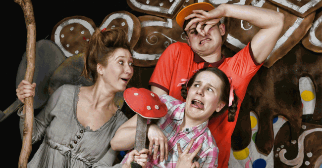 Na zdjęciu trójka aktorów, dwie kobiety i jeden mężczyzna. Aktorka grająca wiedźmę trzyma w ręku laskę oraz grzyba muchomora. Mężczyzna trzyma ręce zatykając nos. Druga kobieta odsuwa się od wiedźmy w geście obrzydzenia. 